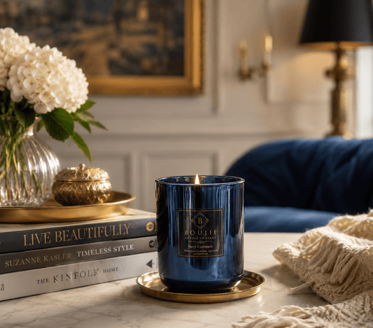 Styled photo of Boujie Navy Cashmere soy candle with pomegranate and lily accents